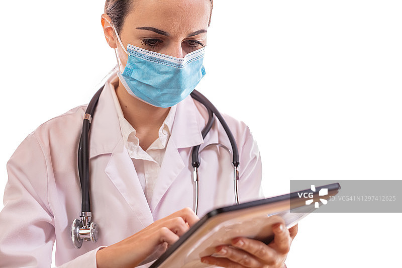 戴口罩的医生使用平板电脑图片素材