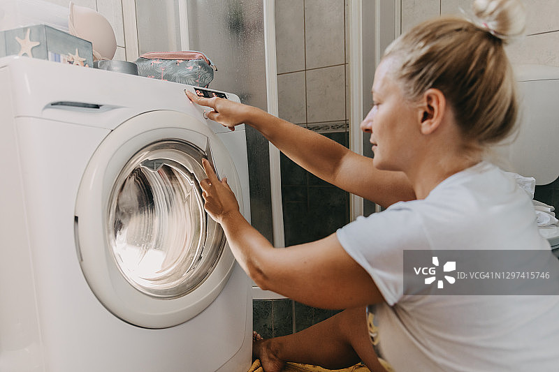 女人选择洗衣机程序图片素材