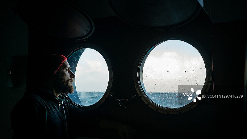 在航行船只舷窗旁的旅客图片素材