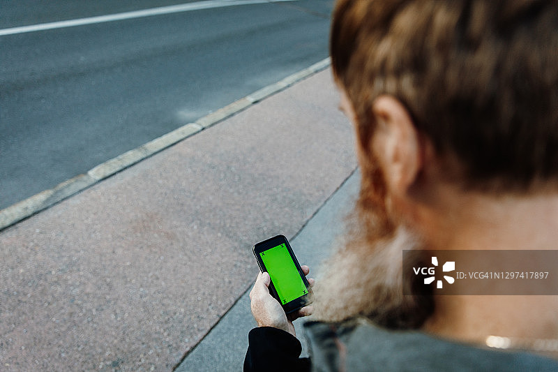 使用带绿屏手机的年长男人图片素材