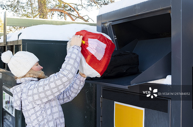 白人女孩将衣物放入服装回收箱，为了生态和再利用图片素材