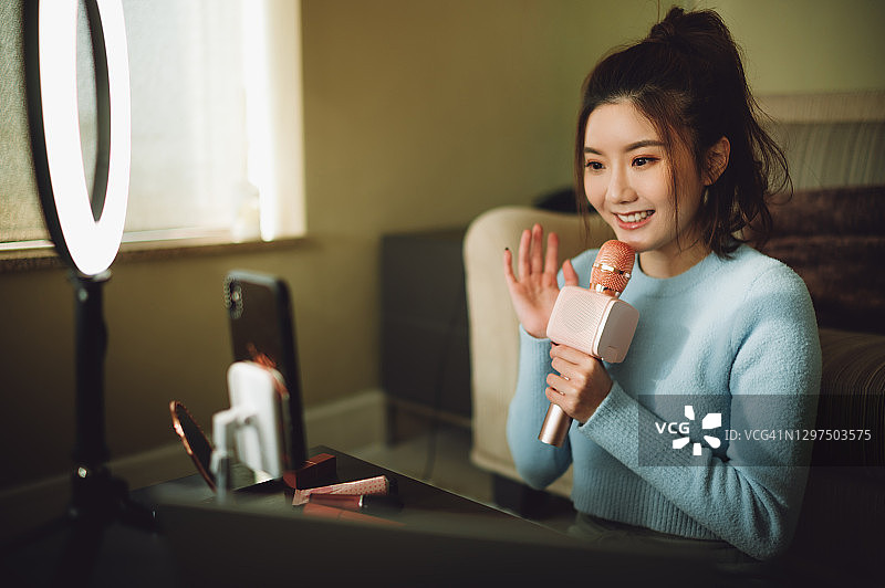 为社交媒体和互联网进行直播的快乐亚洲年轻女子图片素材