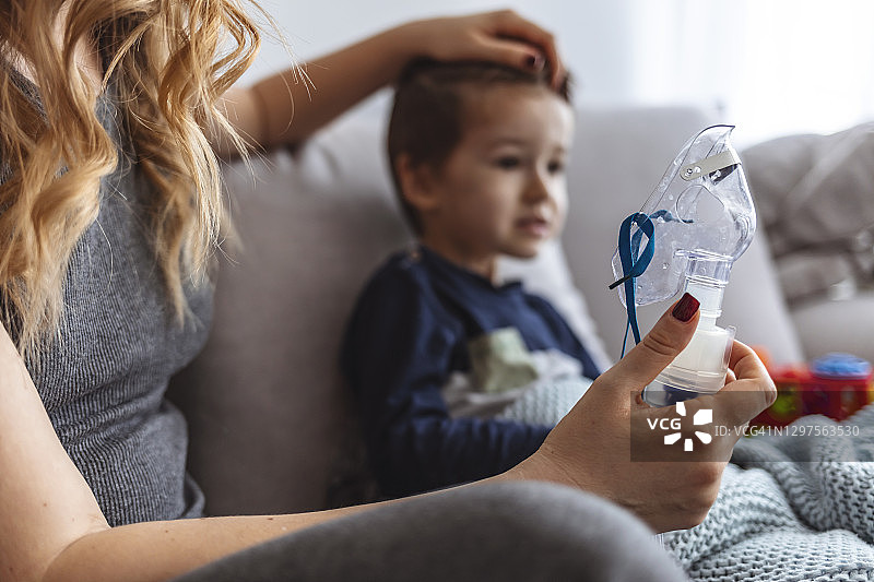 年轻女人和儿子用雾化器做吸入治疗图片素材