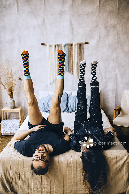 情侣穿着圆点袜子躺在床上图片素材