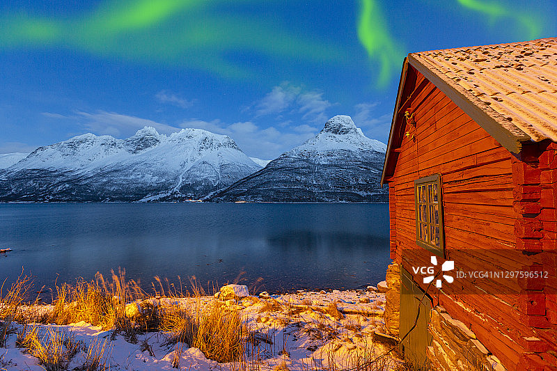 挪威北部极光下的渔村和北冰洋图片素材