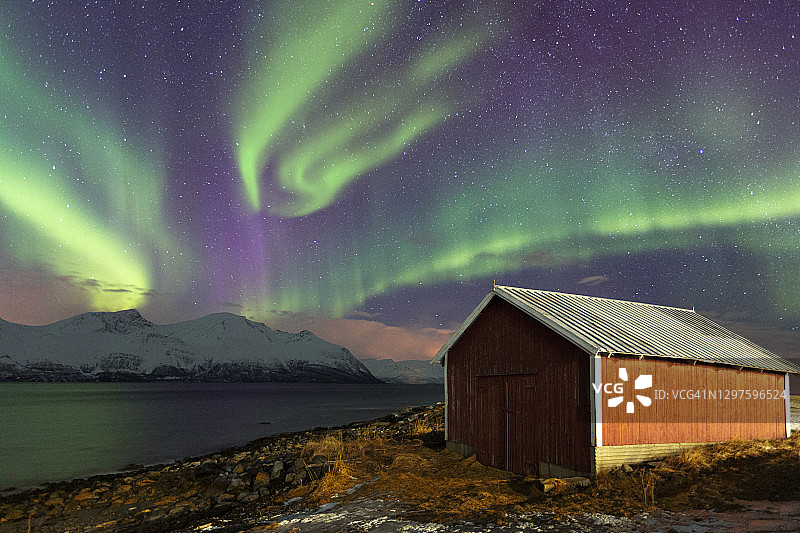 挪威海边渔民小屋上的北极光图片素材