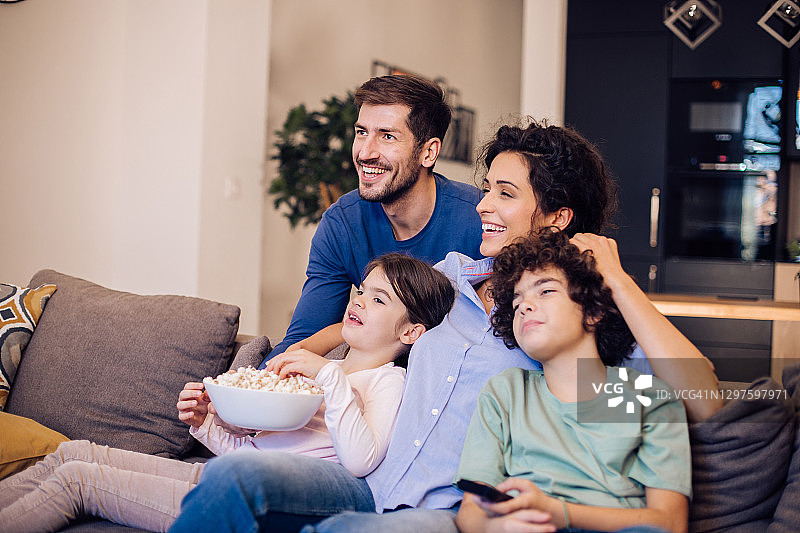 幸福的父母和两个小孩一起看电影图片素材