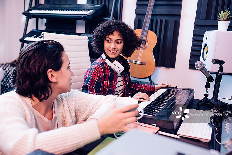 两位年轻的音乐家在音乐工作室工作图片素材