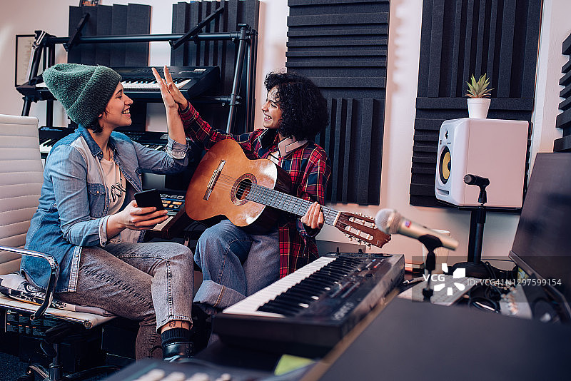 录制歌曲时庆祝成功的两位音乐家图片素材