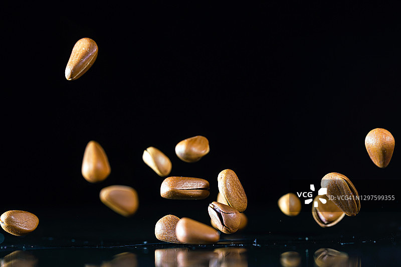 黑色背景中飞舞的松子图片素材