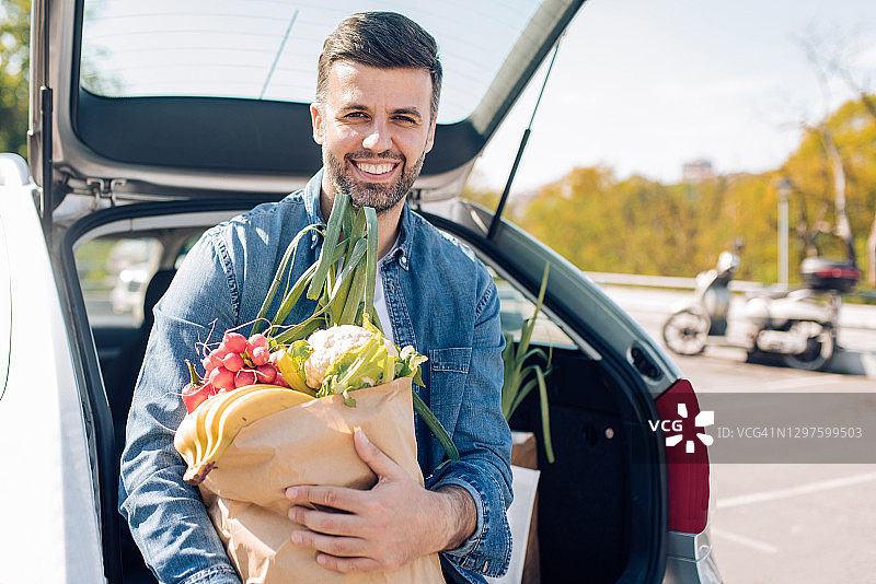 在超市前停车场摆姿势的男人肖像图片素材