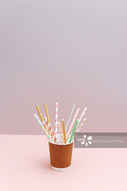 粉色背景上的纸咖啡杯与纸吸管图片素材