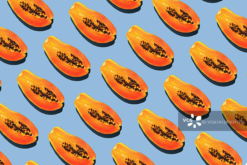 蓝色背景上的重复木瓜图案图片素材