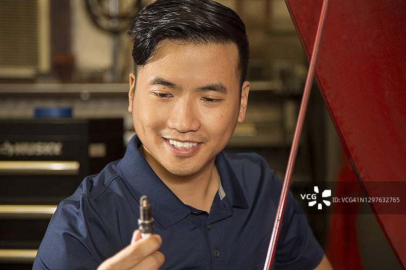 中年亚洲机械师在车盖下工作图片素材