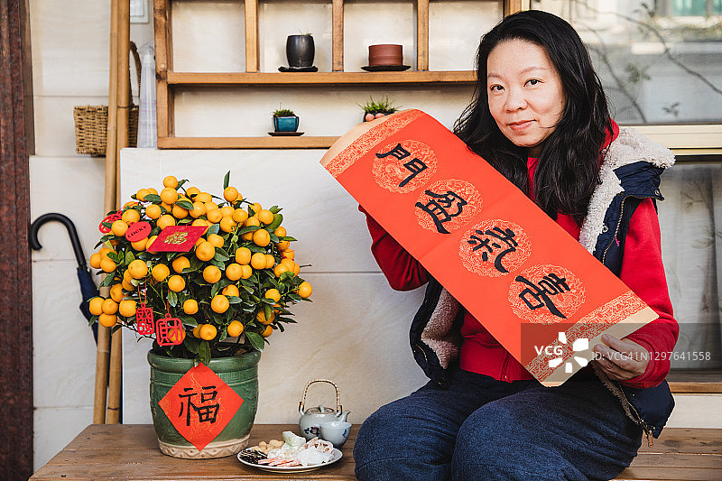 坐在前院拿着中国对联的年长的亚洲女人图片素材