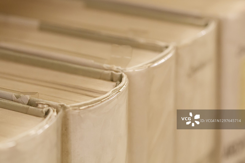 一排纸张泛黄的旧硬壳书图片素材