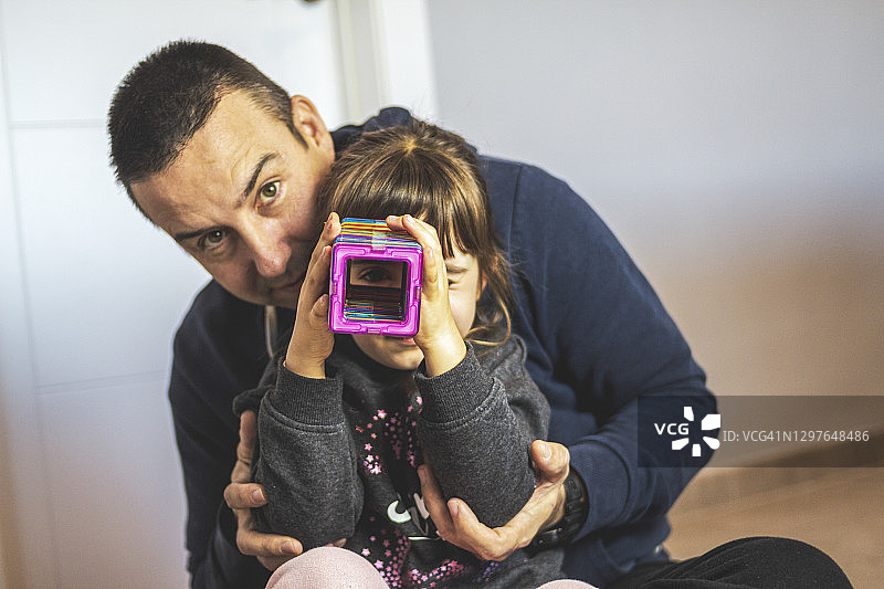 漂亮女孩和父亲一起玩磁力积木图片素材