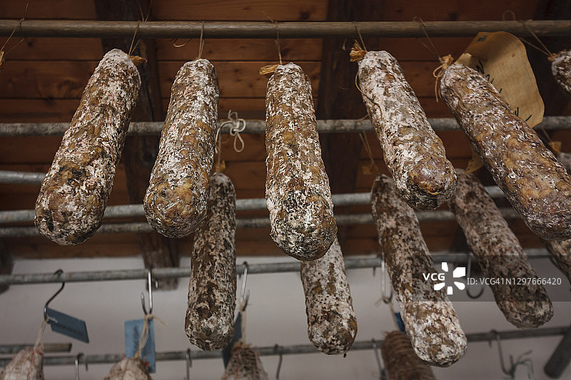 手工意大利腊肠挂在乡村地窖里调味图片素材