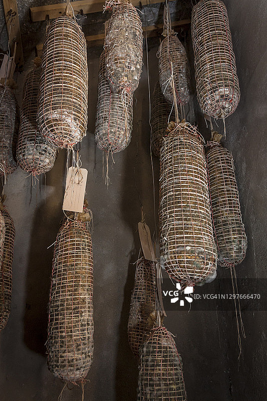 手工意大利腊肠挂在乡村地窖里调味图片素材