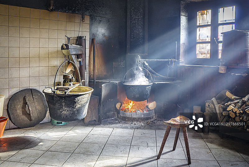 烟雾缭绕的老式奶酪实验室。房间内有传统的奶酪生产设备和阳光透过窗户照射进来图片素材