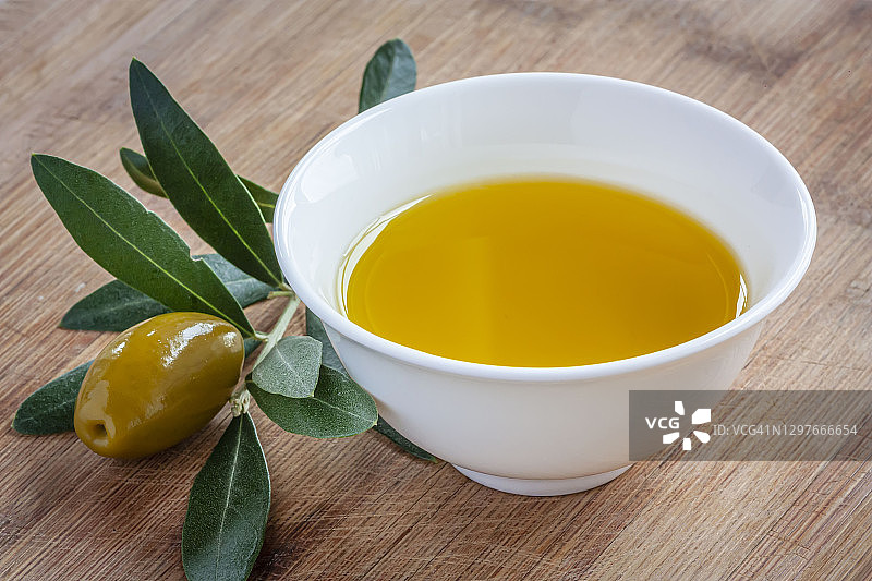 特级初榨橄榄油碗，旁边有橄榄枝和果实图片素材