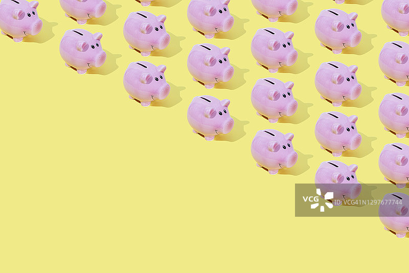 黄色背景上的粉色小猪储蓄罐图片素材