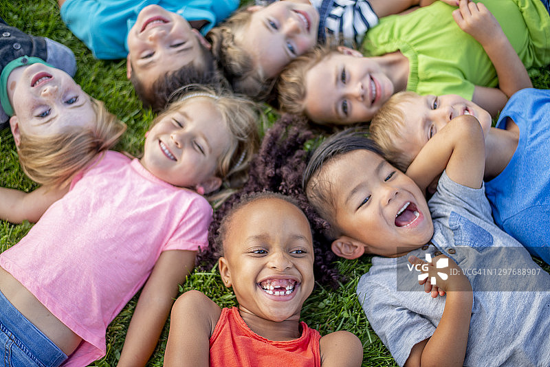 孩子们躺在草地上欢笑的航拍镜头图片素材