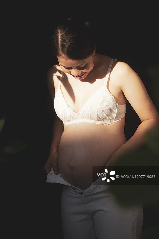享受放松的亚裔孕妇（浅色调，高对比度）图片素材