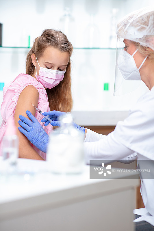 穿防护服的女医生为女孩注射流感疫苗图片素材