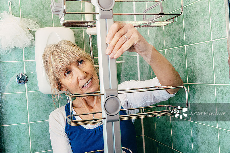 女人修理淋浴置物架图片素材