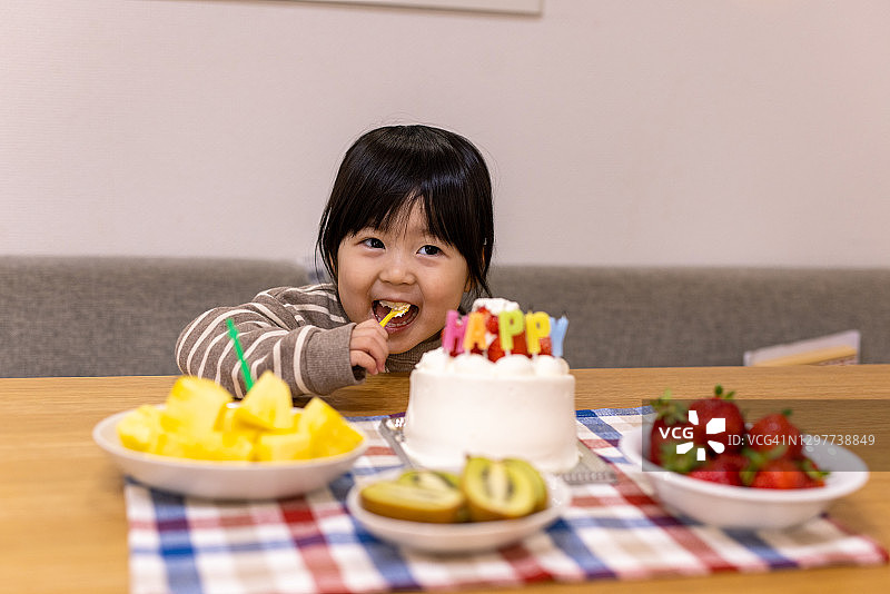 小女孩在生日派对上吃蛋糕图片素材