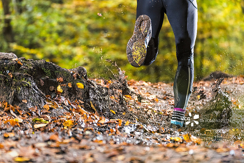 在德国卡佩尔贝格秋季森林泥泞中奔跑的男子图片素材