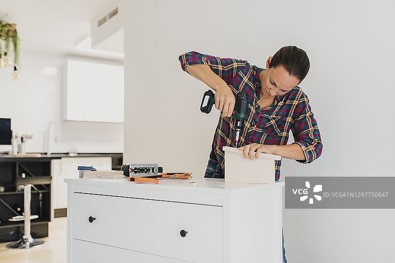 工匠在家使用电动螺丝刀图片素材