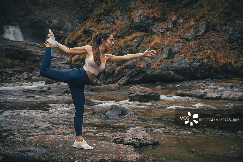 在西班牙韦斯卡省奥尔德萨国家公园的河边森林里做瑜伽的运动员图片素材