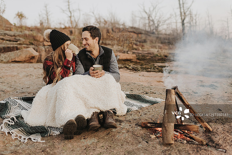 坐在冒烟的篝火前的年轻夫妇图片素材