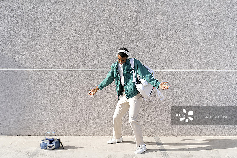 戴耳机背包的年轻男人在收音机旁跳舞图片素材