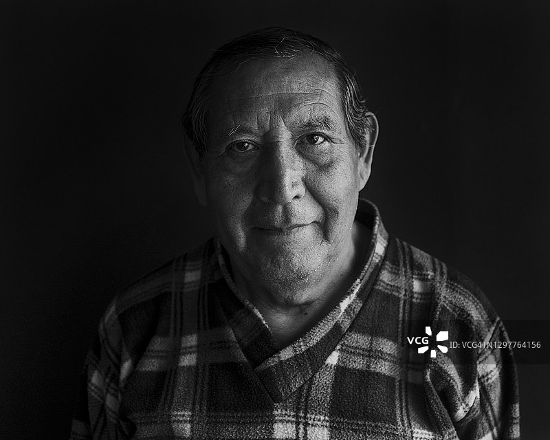 在黑色背景下微笑的男子图片素材