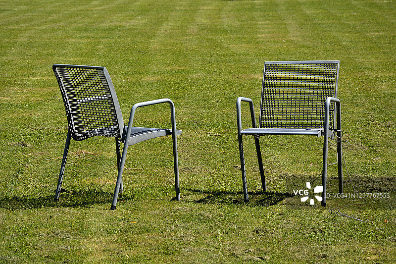 草坪上的两把空花园椅图片素材