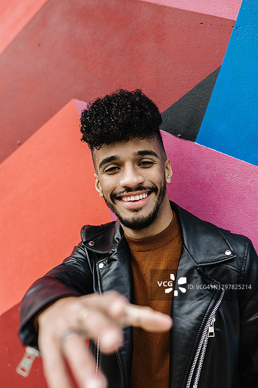 站在彩色墙前的快乐男人图片素材