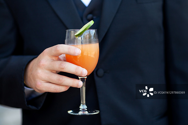 身穿西装的男人拿着鸡尾酒图片素材