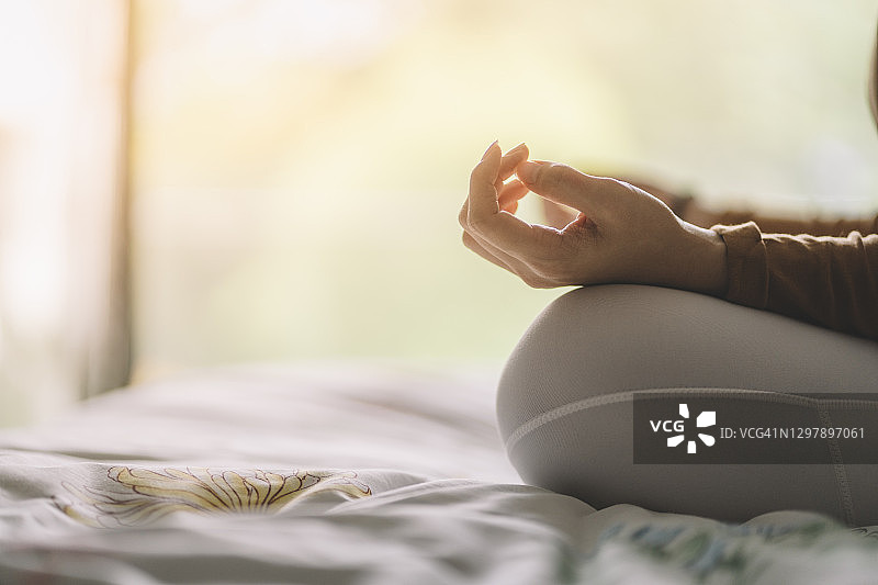 亚洲中国女人在卧室做瑜伽的手部特写图片素材