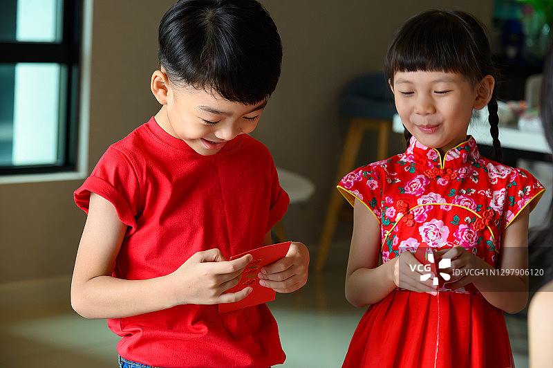 中国新年期间，亚洲儿童收到父母红包，感到兴奋和快乐图片素材