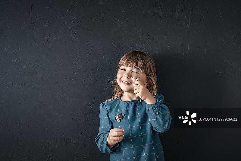 小女孩用放大镜观察图片素材