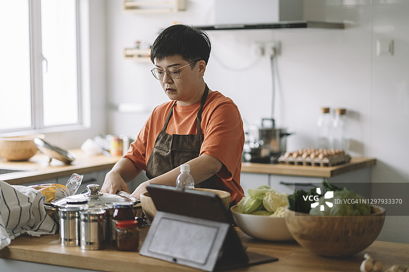 中国亚洲母亲在厨房准备饭菜图片素材