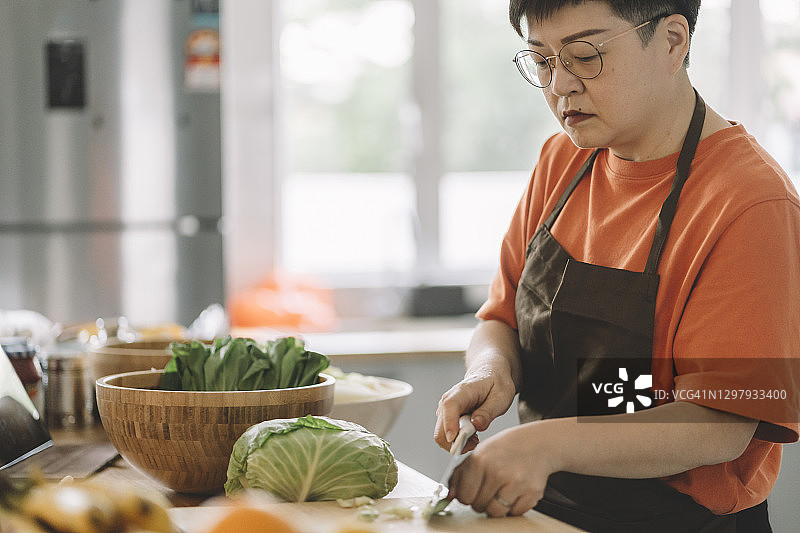 中国母亲在厨房切菜准备饭菜图片素材