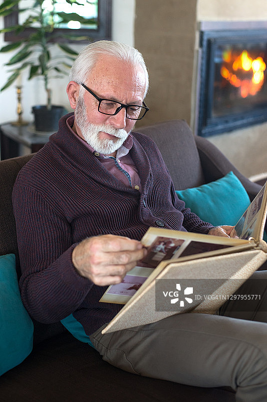 年长的男人看着童年相册图片素材