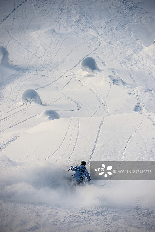 滑雪者在完美的粉雪坡上滑降图片素材