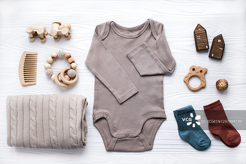 白色背景上的新生婴儿服装、毯子、木制玩具、磨牙器和配件图片素材