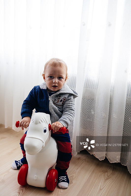 男孩骑玩具马图片素材