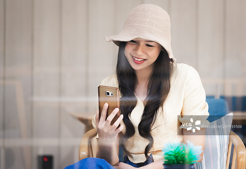 年轻漂亮的女人在咖啡店休息时使用智能手机图片素材